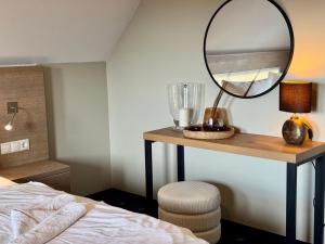 a bedroom with a table with a mirror and a bed at Ferienhaus Strandperle in Loddin +21 photos