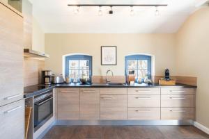 a kitchen with wooden cabinets and counters at Ferienhaus Strandperle in Loddin