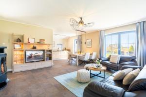a living room with a couch and a tv at Ferienhaus Strandperle in Loddin
