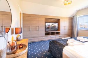 a hotel room with a bed and a television at Ferienhaus Strandperle in Loddin