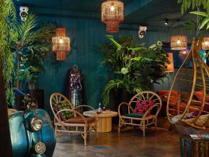 a room with chairs and a table and plants at 25hours Hotel The Trip in Frankfurt