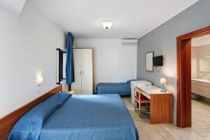 a hotel room with a blue bed and a desk at Marina Living Rooms and Pool in Paestum