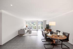 a dining room with a table and chairs and a living room at Chasa Miramunt 2 in Scuol +8 photos