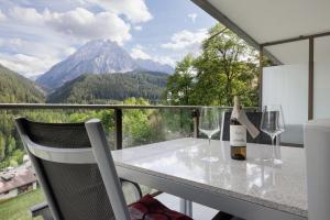 a table with wine glasses and a view of mountains at Chasa Miramunt 2 in Scuol