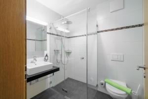 a bathroom with a toilet and a sink and a shower at Chasa Miramunt 2 in Scuol