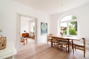 a white living room with a table and chairs at Ferienhaus Stranden Westfehmarn in Fehmarn