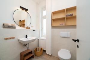 a bathroom with a sink and a toilet and a mirror at Ferienhaus Stranden Westfehmarn in Fehmarn +80 photos
