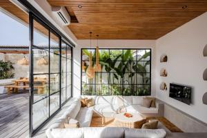 a living room with white furniture and glass windows at The Young Villas - Canggu in Canggu