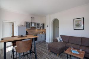 a living room and kitchen with a couch and a table at Ankerplatz über dem Hafen - Pub in Pellworm