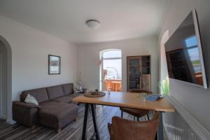 a living room with a couch and a table at Ankerplatz über dem Hafen - Pub in Pellworm +3 photos