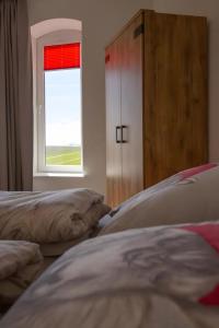 a bedroom with two beds and a window at Ankerplatz über dem Hafen - Pub in Pellworm