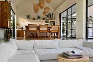 a living room with a white couch and a table at The Young Villas - Canggu in Canggu