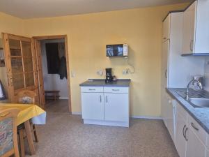 a kitchen with a sink and a counter top at Feldblick in Krummhörn +7 photos