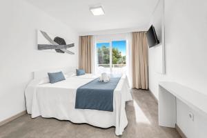 a white bedroom with a bed and a window at HSM Lago Park in Playa de Muro +52 photos