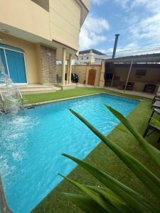 a swimming pool in front of a house at Marina Breeze hotel in Manta +7 photos