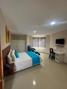 a bedroom with a bed and chairs and a desk at Marina Breeze hotel in Manta