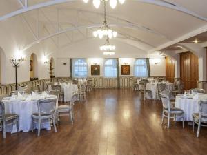 a banquet hall with white tables and chairs at Mercure Medias Binderbubi Hotel And Spa in Mediaş
