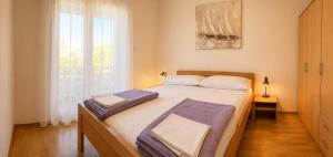 a bedroom with a large bed and a window at Apartments Mohar II in Baška