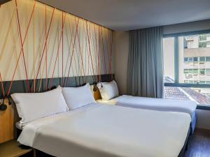 a hotel room with two beds and a window at ibis Styles Porto Alegre Moinhos de Vento in Porto Alegre +89 photos