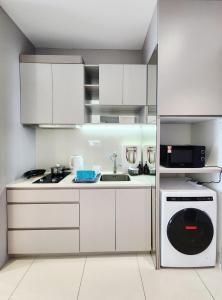 a kitchen with white cabinets and a sink and a dishwasher at Luxury DoubleTree Hill10 Residence at i-City , free parking H2901 in Shah Alam