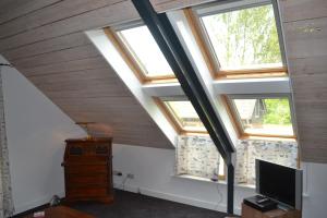 a room with three windows and a flat screen tv at Het Steenuiltje in Sint-Oedenrode