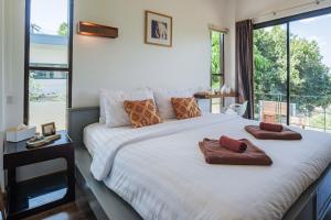 a bedroom with a large white bed with a large window at Sam Lanta in Ko Lanta