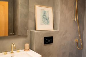 a bathroom with a sink and a picture on the wall at Farmhouse with Loch Views in Gartocharn +33 photos