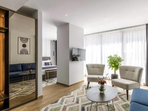 Mövenpick Hotel Lalez Durres في دراس: غرفة معيشة بها كرسيان ومرآة