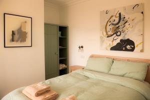 a bedroom with a bed and a painting on the wall at Farmhouse with Loch Views in Gartocharn