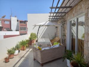 a balcony with a wicker chair and an umbrella at Residence Fazenda - Piscina in Praia
