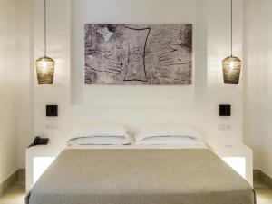 a bedroom with a bed with a painting on the wall at Baia Delle Zagare - Handwritten Collection in Mattinata