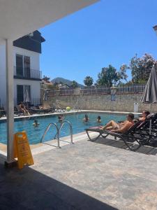 a group of people sitting in chairs in a swimming pool at çam otel in Fethiye
