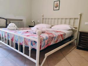a white bed with a blanket and pillows on it at La casa di Viola in Bardolino