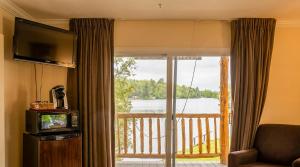 a room with a large window with a view of a lake at Gauthier's Saranac Lake Inn in Saranac Lake