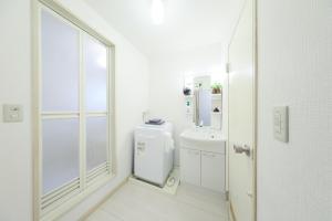 a white bathroom with a sink and a mirror at Shonan Beach&Sun in Chigasaki +64 photos