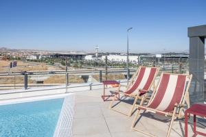 a pair of chairs and a swimming pool on a roof at Codomo Living Granada in Granada