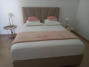 a large bed in a room with two tables at Residence Fazenda - Piscina in Praia