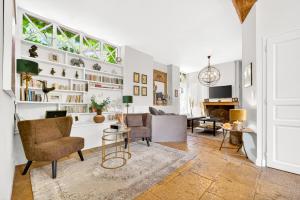 a living room with white walls and a large window at Fanny à la Campagne in Nantoux
