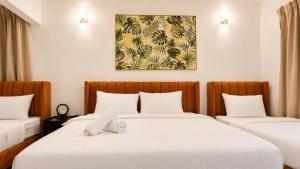 a bedroom with two beds and a painting on the wall at Bungalow Perkasa in Kuala Lumpur +35 photos