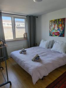 a bedroom with a large bed with two slippers on it at B&B Het Heusje in Zaandam