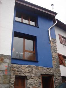 un edificio azul con ventanas laterales en La Cuadrina de Anton, en Pajares