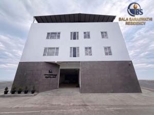 a large white building with a large entrance at Bala Saraswathi Residency in Tuticorin +17 photos