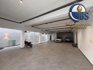 a garage with a baja synergy car dealership at Bala Saraswathi Residency in Tuticorin