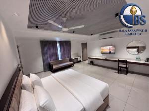a hotel room with a large bed and a television at Bala Saraswathi Residency in Tuticorin