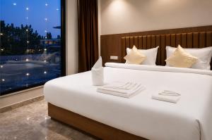 a large white bed in a room with a window at Hotel Rio in Siliguri