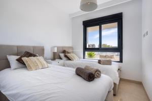 two white beds in a room with a window at Paradise Resort 315 in San Miguel de Salinas