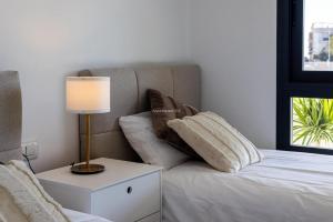 a bedroom with a bed with a lamp and pillows at Paradise Resort 315 in San Miguel de Salinas +16 photos