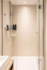 a shower with a glass door in a bathroom at Hôtel Le Montmartre Saint Pierre in Paris +41 photos
