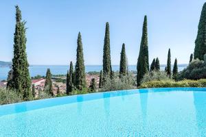 a swimming pool in a garden with trees at Casa 3 Rose Lake View and Pool in Toscolano Maderno