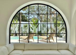 an arched window in a living room with a couch at Melrose x The Young Villas in Uluwatu